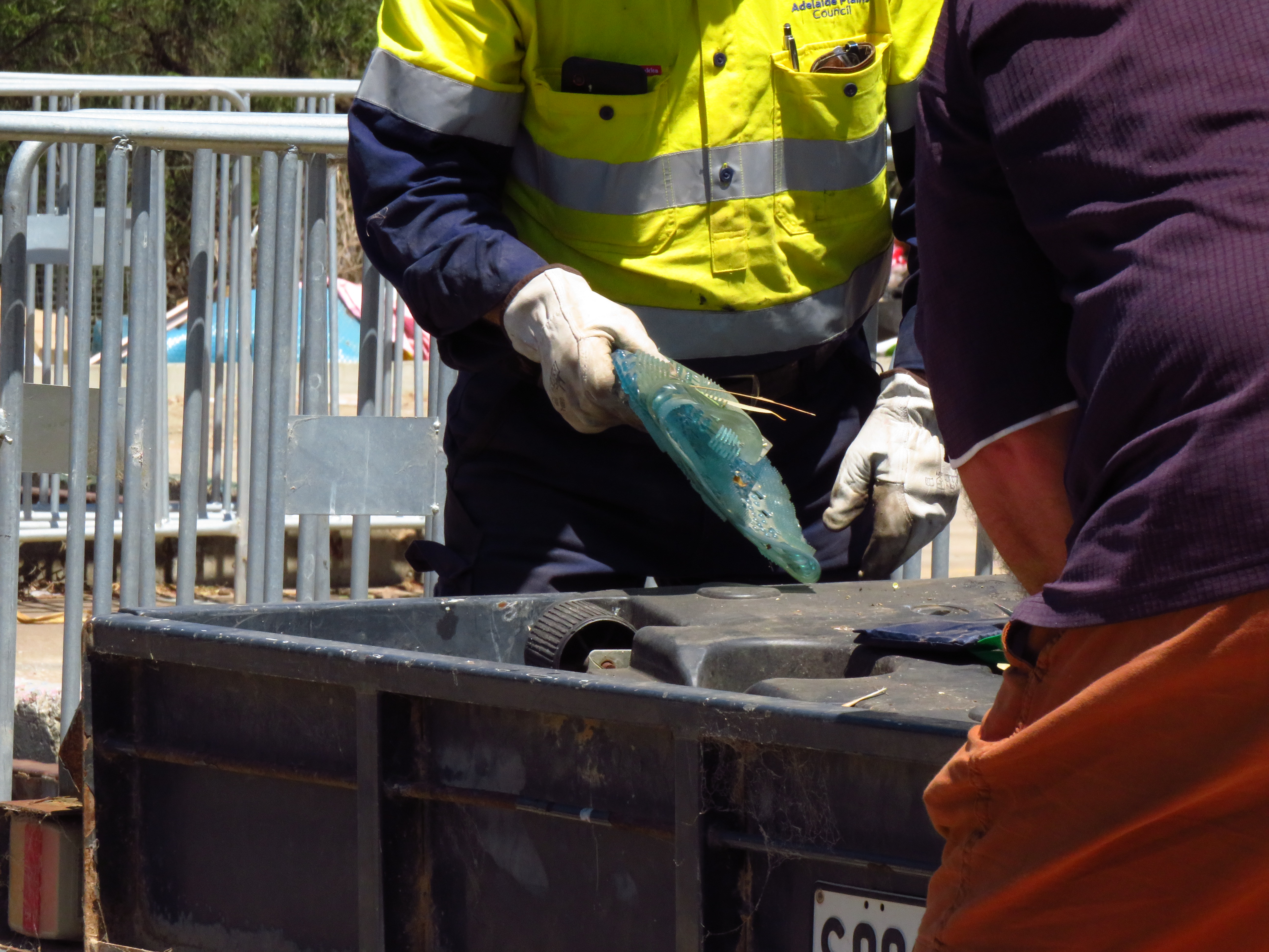 A person taking rubbish out of a trailer to dispose of at the resource recovery centre.